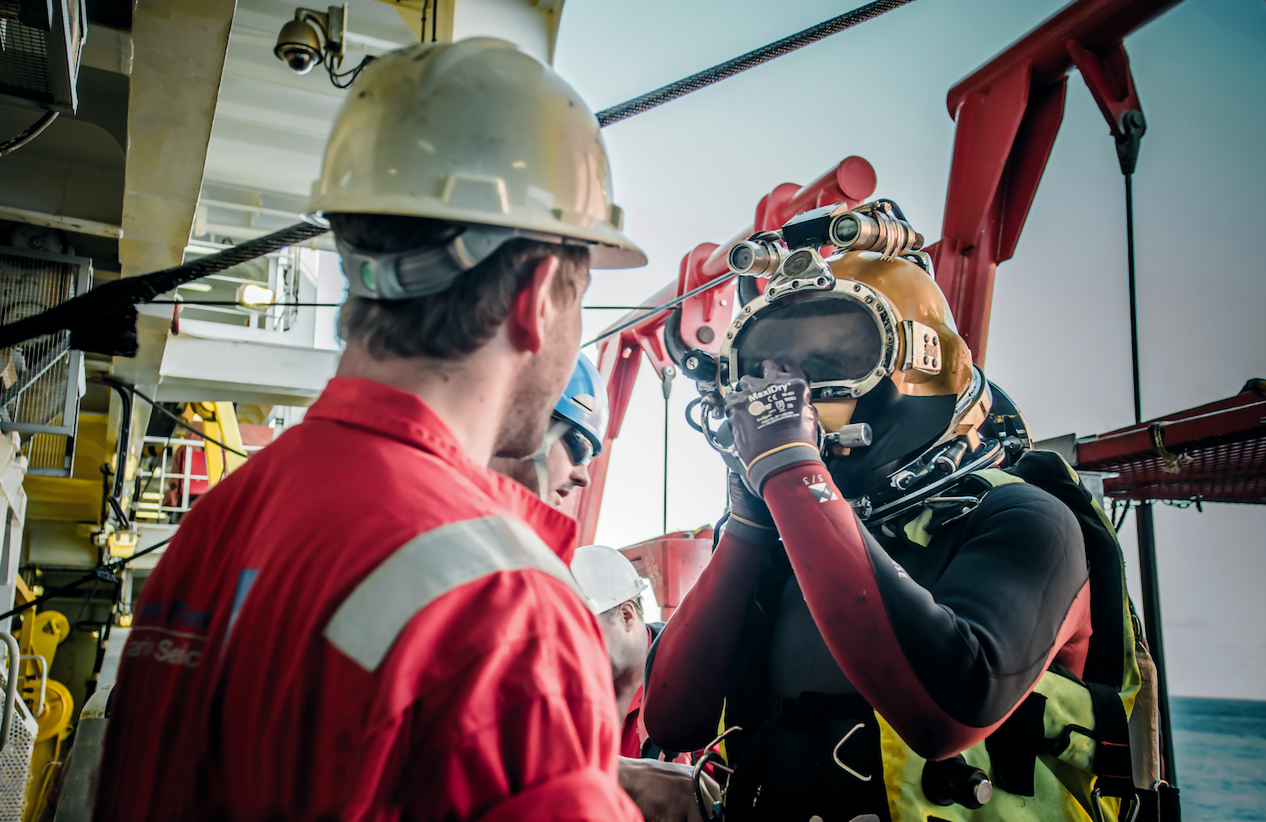 Two men, one in hard hat and one in a yellow diving helmet